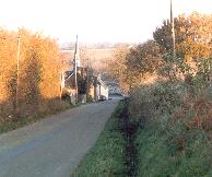 Vu de la route de Dollon, le clocher est presque invisible. L'ancienne cole l'est totalement !